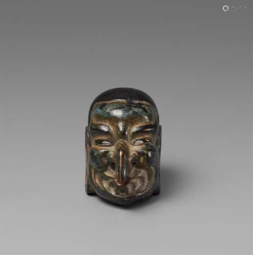 A wood and lacquer netsuke of a gigaku mask. Late 19th/early...
