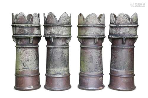 A SET OF FOUR SALT-GLAZED CHIMNEY POTS, each with crown-top....