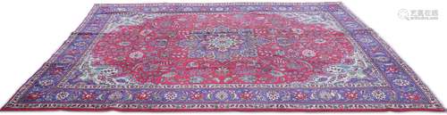 A PERSIAN TABRIZ CARPET, the red field with cream and blue c...