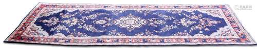 A PERSIAN SAROUK RUNNER, the dark blue field with floral spr...