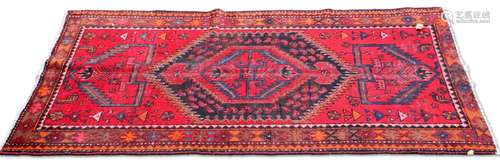 A PERSIAN HAMADAN RUG, the brick red field with large zigzag...