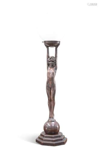 AN ART DECO-STYLE PATINATED METAL FIGURAL TABLE LAMP, in the...