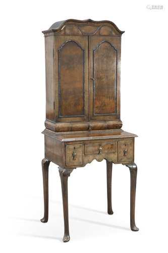 A WALNUT CABINET ON STAND, the upper section with a pair of ...