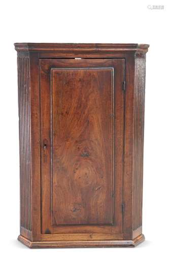 A GEORGE III OAK AND ELM HANGING CORNER CUPBOARD, with field...