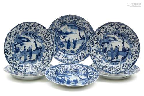 A set of six large blue and white plates with figures