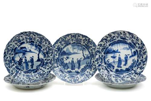 A set of five large blue and white plates with figures