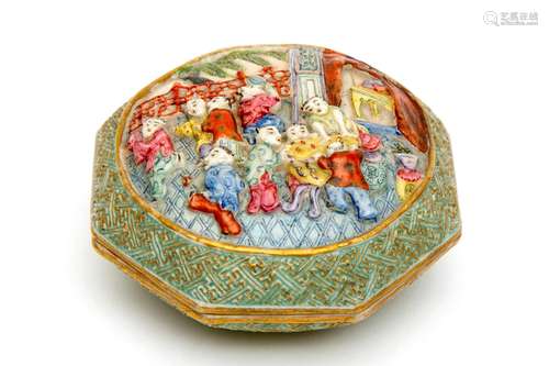 An octagonal famille rose paste box with relief figures