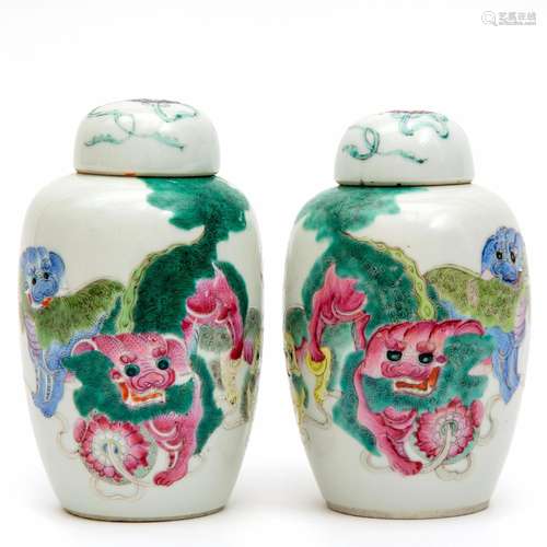 A pair of covered famille rose vases with foo dogs