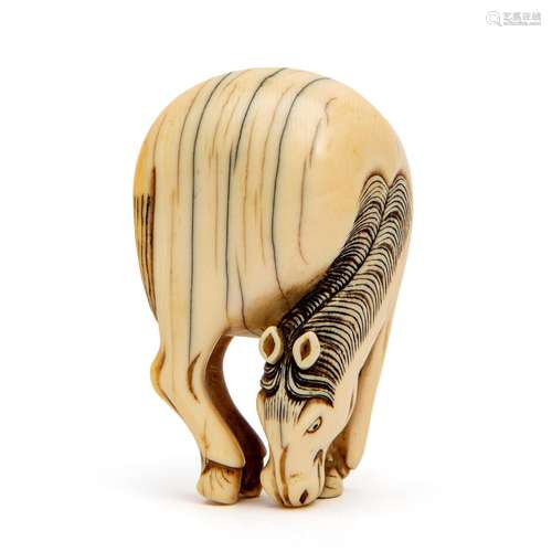 An ivory carved grazing horse netsuke