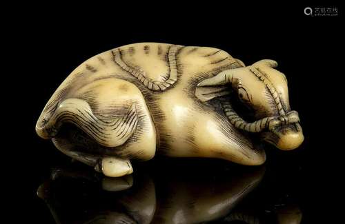 A HORN NETSUKE WITH A RECUMBENT OX Japan, 19th century