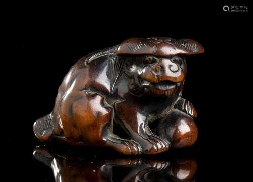 A BOXWOOD NETSUKE WITH A SHISHI Japan, 19th century