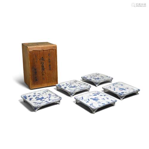 A set of five blue and white footed trays