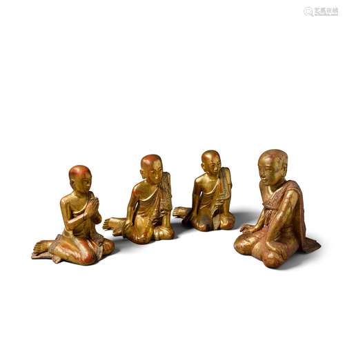 A group of four lacquered wood attendant monks and a kneelin...