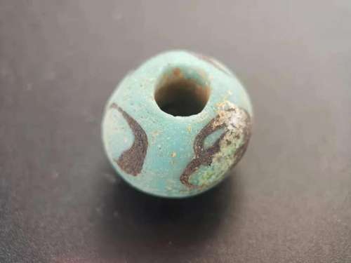 A SPRING AND AUTUMN PERIOD INK PATTERN GLASS BEAD