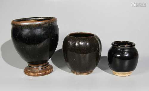 A SET OF THREE BLACK GLAZED JARS