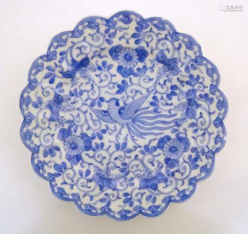 An Oriental blue and white plate with scalloped ed…