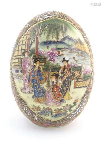 A Japanese model of an egg decorated with four lad…