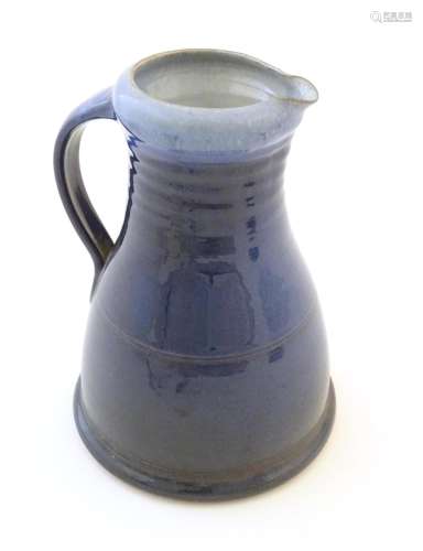 A studio pottery jug with a blue glaze, ribbed nec…