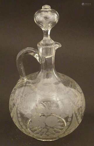 A glass ewer / jug with etched decoration, loop ha…