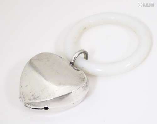 A white metal heart shaped rattle with teething ri…