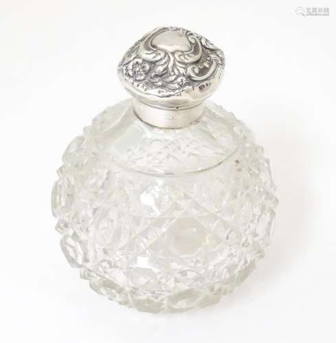 A cut glass perfume / scent bottle with silver lid…