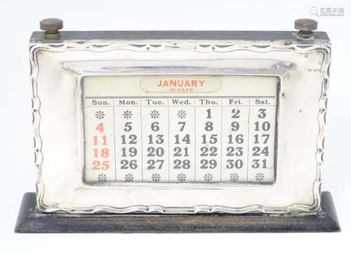 An Art Deco desk calendar with silver surround, ha…