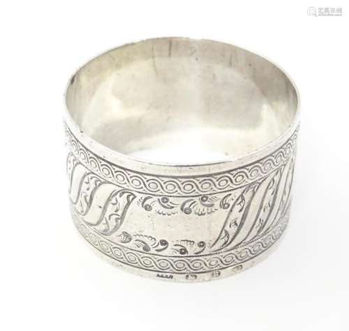 A Victorian silver napkin ring with engraved decor…