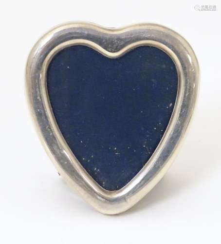 A photograph frame of heart form with a silver sur…