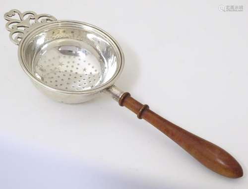 A silver strainer with tuned wooden handle . Hallm…