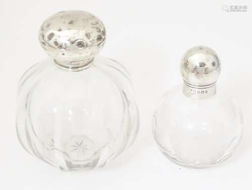 Two glass scent / perfume bottles with silver tops…