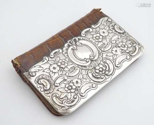 A leather purse with silver embossed detail to fro…