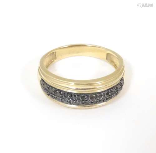 A 9ct gold ring set with black diamonds in a doubl…