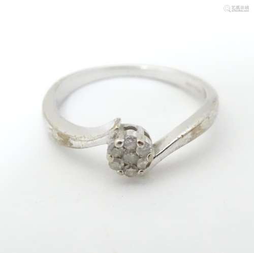A 9ct white gold ring with diamonds in a daisy set…