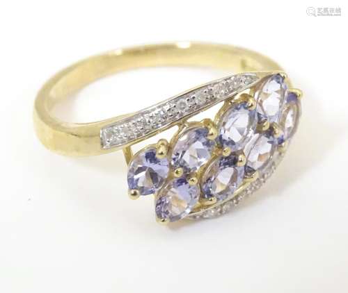 A 9ct gold ring set with tanzanite coloured stones…