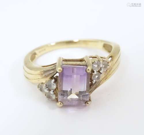 A 9ct gold ring set with amethyst and white topaz.…