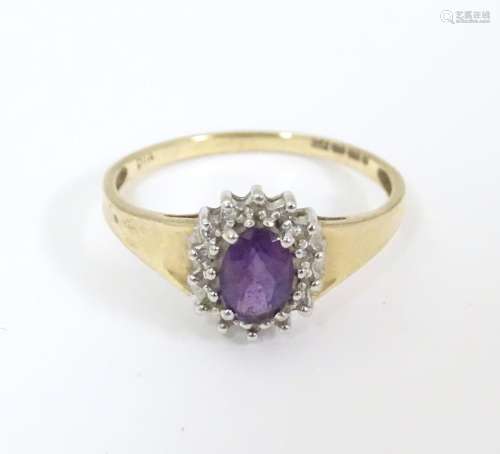 A 9ct gold ring set with central amethyst bordered…