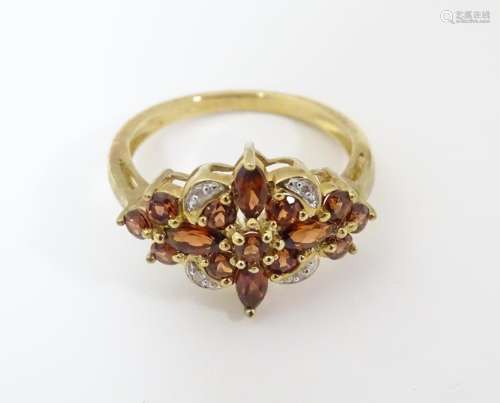 A 9ct gold ring set with garnets and diamonds. Rin…