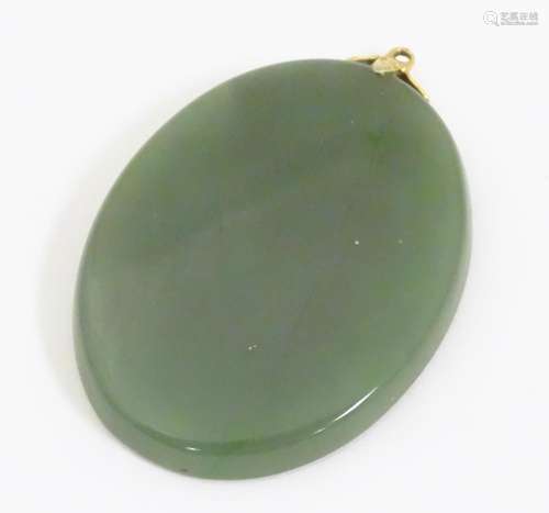 An oval jade coloured pendant. Approx 1 3/4" long …