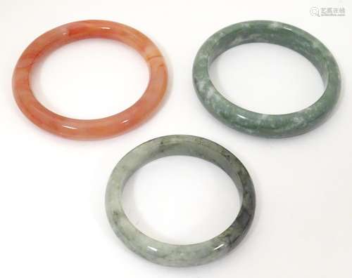 Three assorted hardstone bracelets of bangle form …