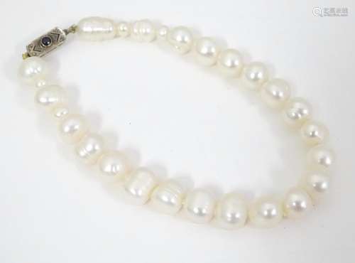 A pearl bracelet with 9ct gold clasp set with blac…