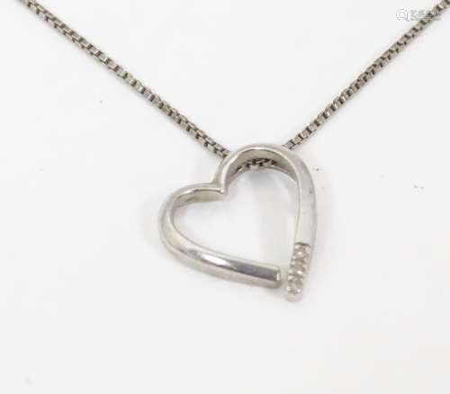 A silver necklace with heart shaped pendant set wi…
