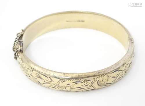 A silver gilt bracelet of bangle form with engrave…