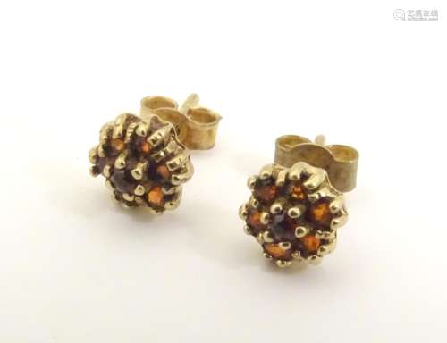 A pair of 9ct gold stud earrings set with red ston…