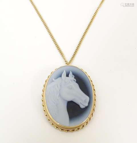 An oval pendant / brooch set with horse head decor…