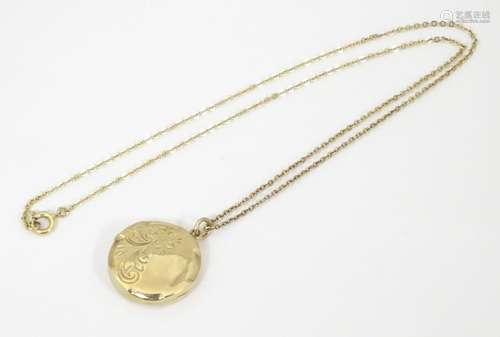 A 9ct gold pendant locket with engraved decoration…