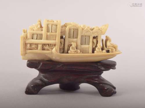 A SMALL CARVED IVORY MODEL OF A JUNK and wooden stand, 8cm l...