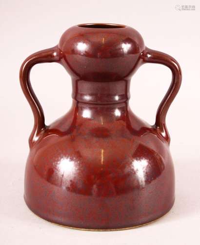 A CHINESE OX RED SPECKLED GLAZE TWIN HANDLE VASE, six charac...