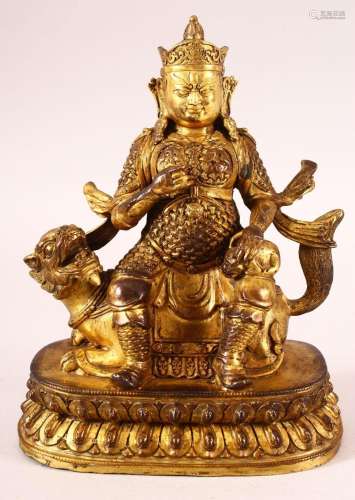 A CHINESE GILT BRONZE MODEL OF A DEITY, possibly Jambhala, s...