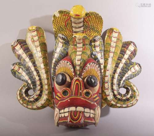 A LARGE SRI LANKAN CARVED AND PAINTED WOODEN MASK, 33cm x 45...