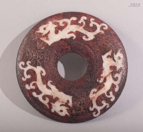 A SMALL CHINESE RED STAINED HARDSTONE BI DISK, with three st...